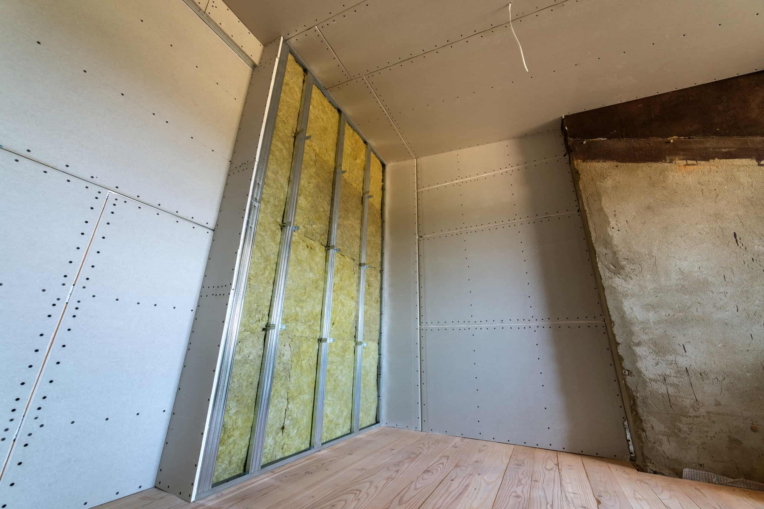 Wall of a room under renovation with mineral rock wool insulation and metal frame prepared for drywall plates. Få pålidelig lydisolering af vægge